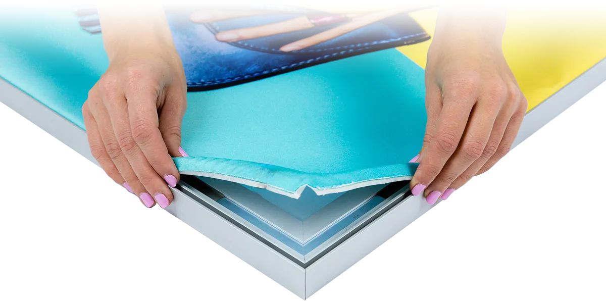 Silicone-edge fabric graphic being pushed into a FastFrame display channel
