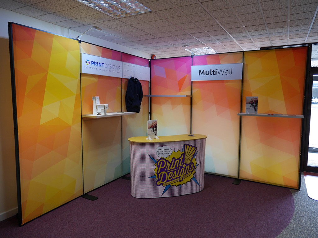 Multiwall display shown in 3M x 3M L Sheped configuration. With shelving, header panels and slatwall hooks